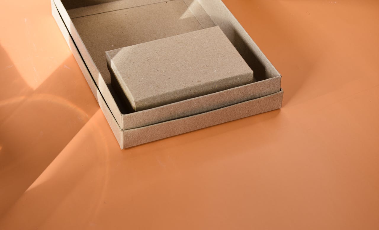 services-04 Close-up of a cardboard box on an orange surface, ideal for packaging themes.